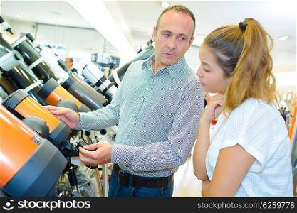 Man and young lady looking at telescopes