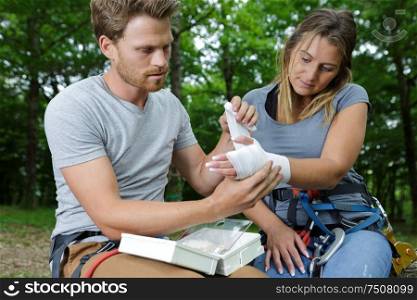 man applying compression bandage to girlfriend injury