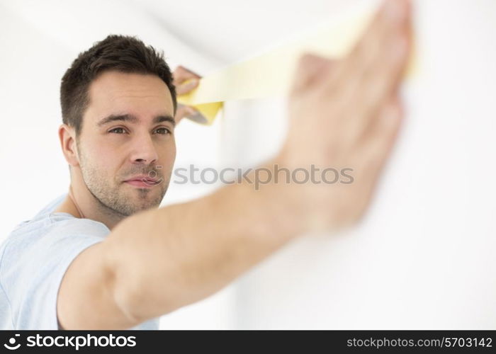 Man applying duct tape on wall