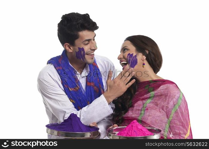 Man applying holi colour on womans face