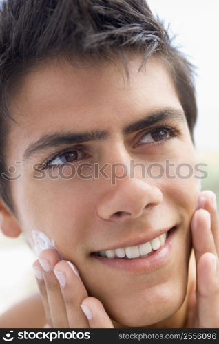 Man applying shaving cream smiling