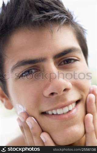 Man applying shaving cream smiling