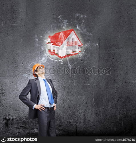 Man architect. Young thoughtful man engineer against dark wall