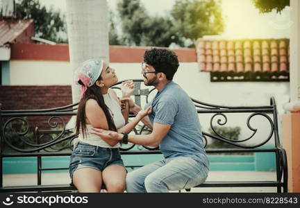 Man arguing with girlfriend sitting in a park. Young couple arguing sitting on a park bench, Concept of aggressive couples in the park. Upset couple arguing on a park bench