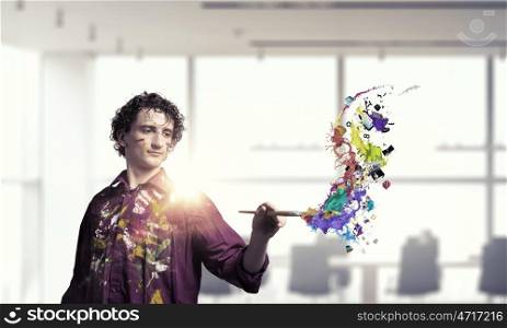 Man artist painting with brush. Young handsome man painter with brush in hand