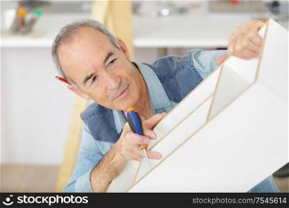 man as senior wood furniture maker