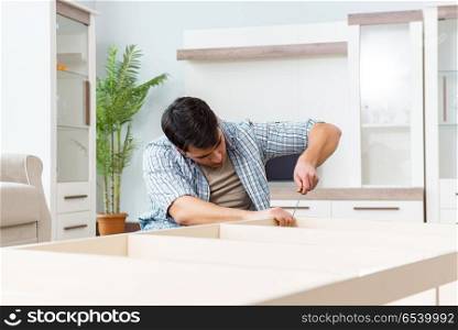 Man assembling furniture at home