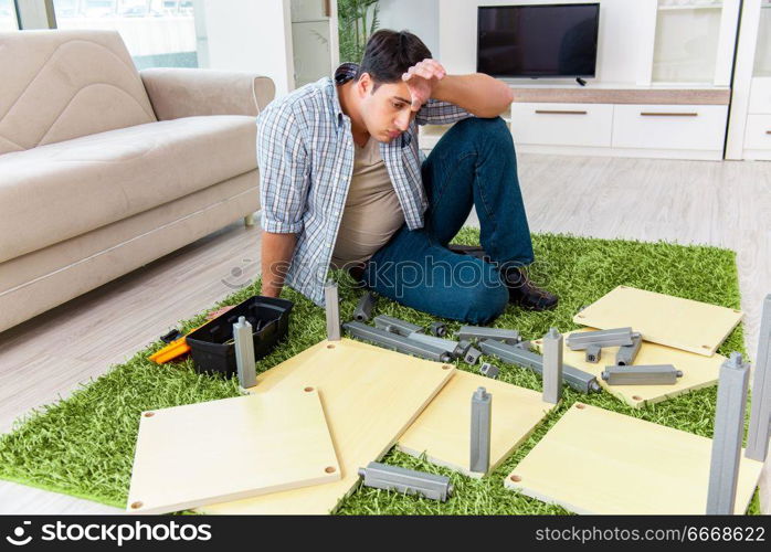 Man assembling furniture at home