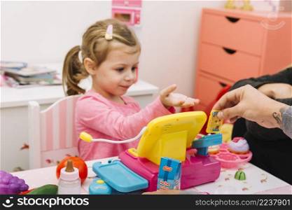 man assisting his daughter while playing with toy