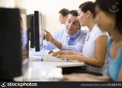 Man assisting woman in computer room