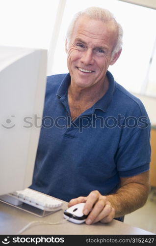 Man at computer smiling (high key)