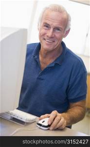 Man at computer smiling (high key)