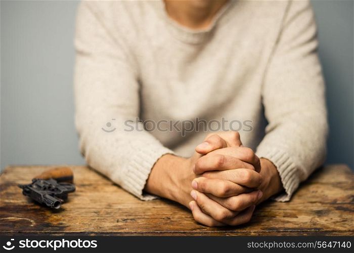 Man at desk with gun is praying