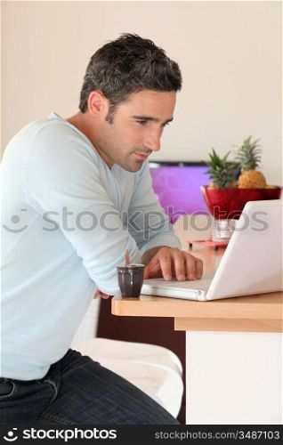 Man at home connected on internet with laptop