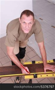 Man at home cutting wooden flooring to size