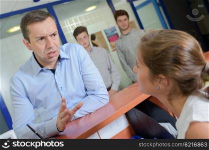 Man at reception desk getting angry