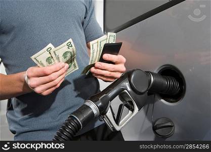 Man at service station, counting money