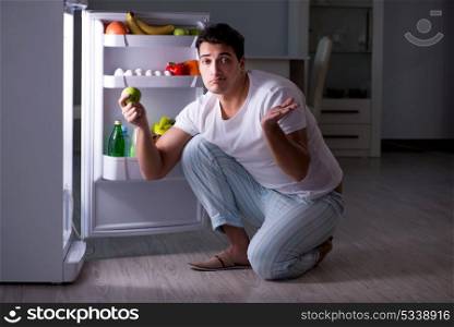 Man at the fridge eating at night