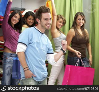 man at the front of a group of casual girls shopping in a store