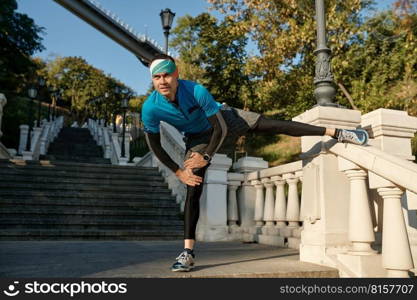 Man athlete doing stretching routine before running up stairs. Fitness, sport and training exercise concept. Man doing stretching routine before running up stairs