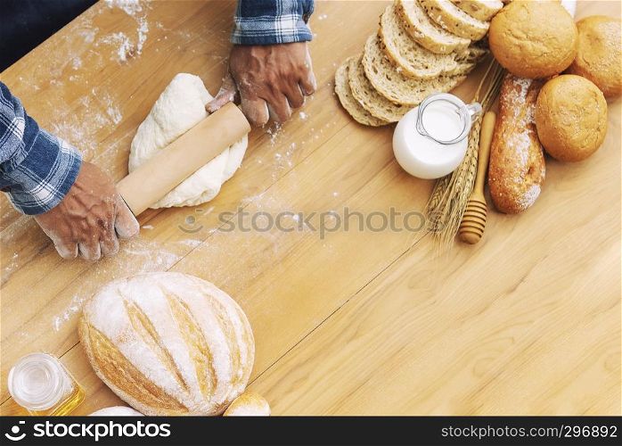 Man baking fresh bread on tray in garden with nature background.