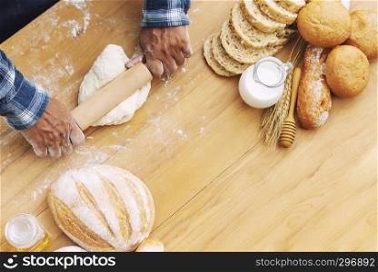 Man baking fresh bread on tray in garden with nature background.