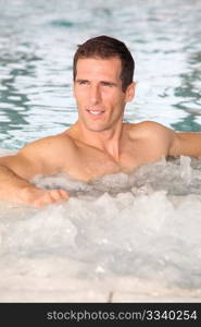 Man bathing in jacuzzi of spa center