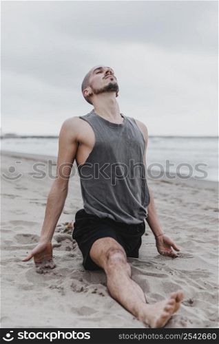 man beach doing split yoga routine