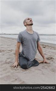 man beach exercising yoga positions