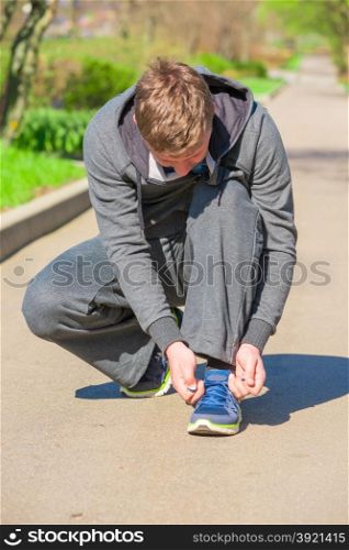 Man before jogging tying the laces from sneaker