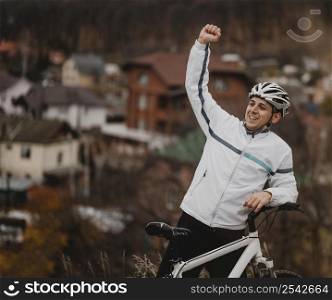 man being victorious after riding his bike