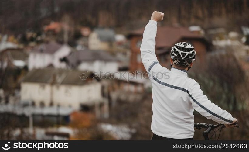 man being victorious after riding his bike with copy space