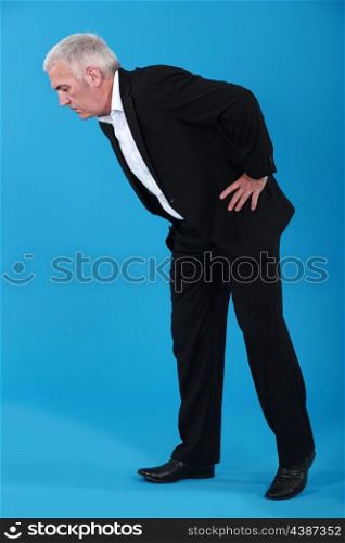 Man bending over to look at something on the floor