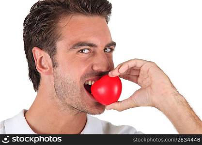 Man biting heart-shaped object