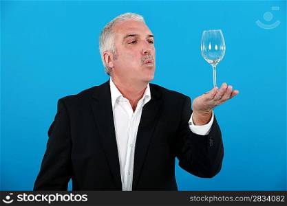 Man blowing a wine glass