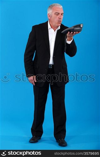 Man blowing dust off of a telephone