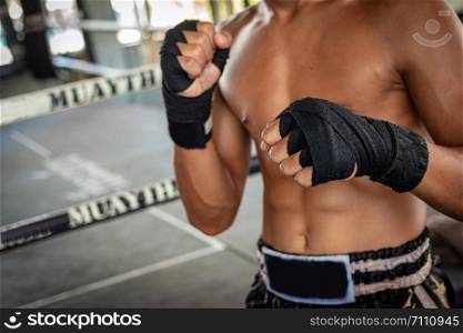 Man boxer wrapping his hand in boxing arena sport.