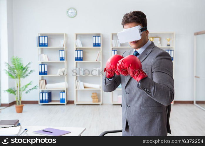 Man boxing in the office with virtual reality goggles
