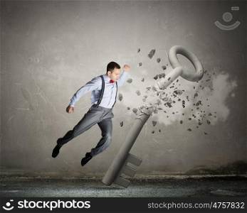 Man break key. Angry businessman crashing stone key with punch