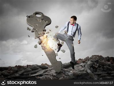 Man break key. Angry businessman crashing stone key with punch