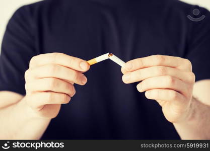 man breaking the cigarette with hands. close up of man breaking the cigarette with hands