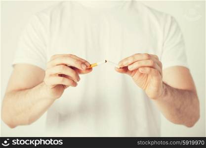 man breaking the cigarette with hands. close up of man breaking the cigarette with hands
