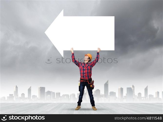 Man builder presenting something. Young smiling craftsman holding with blank banner. Place for text