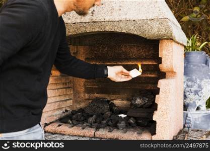 man burning firepit with paper
