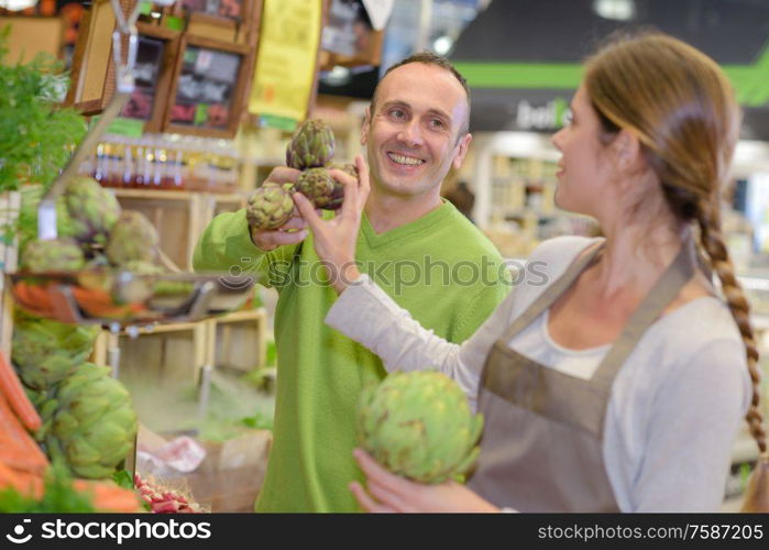 Man buying artichokes in shop