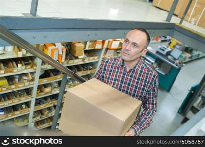 man carring a carton box in a store