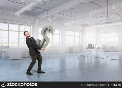 Man carry currency sign. Young businessman in office interior carrying dollar sign
