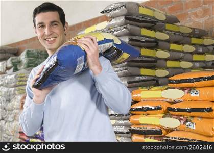 Man carrying a bag of fertilizer on his shoulders