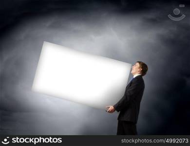 Man carrying banner. Young businessman carrying white blank banner. Place for text