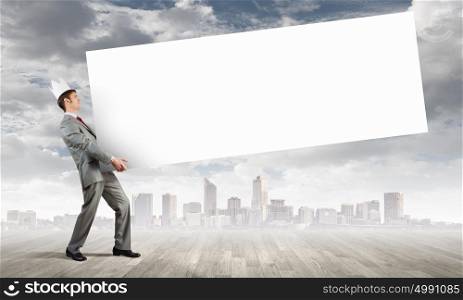 Man carrying banner. Young businessman wearing crown and carrying white blank banner. Place for text